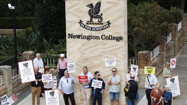 Parents holding placards during a silent protest against Newington College’s transition to a co-ed school, at the Sydney campus in Stanmore. Picture: Richard Dobson