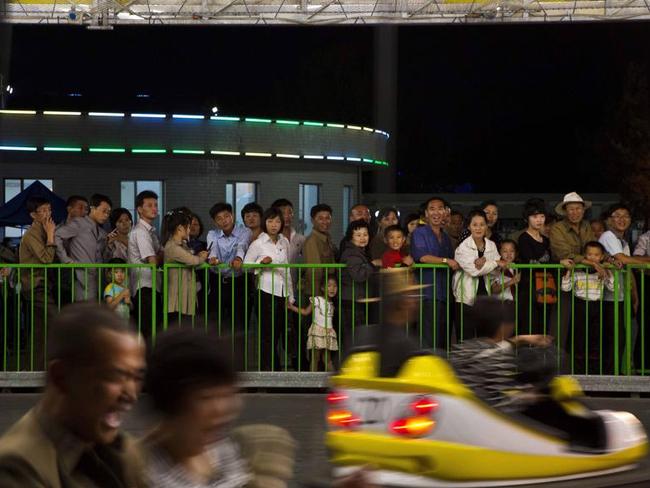 North Koreans wait in line to enter the bumper car ride at the Pyongyang Pleasure Park. Sports are seen as a means of energising and mobilising the masses. Picture: David Guttenfelder/AP