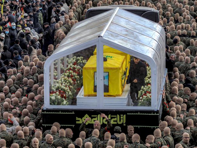 Mourners walk during the funeral procession with the vehicle carrying the coffins of Hezbollah's slain leaders Hassan Nasrallah and Hashem Safieddine. (Photo by IBRAHIM AMRO / AFP)