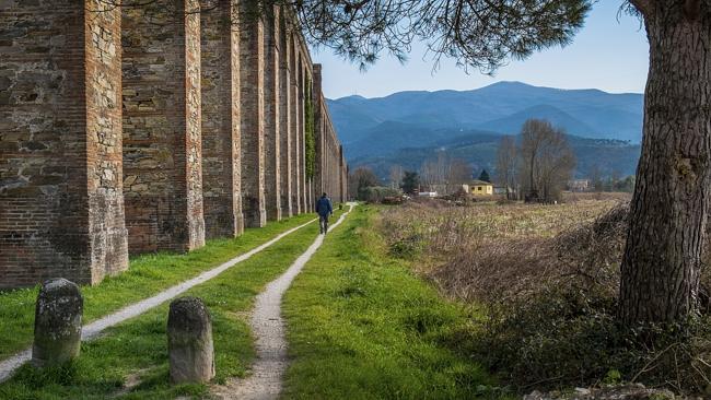 The Via Francigena walking trail passes a historic aqueduct near Lucca, in Tuscany, Italy.