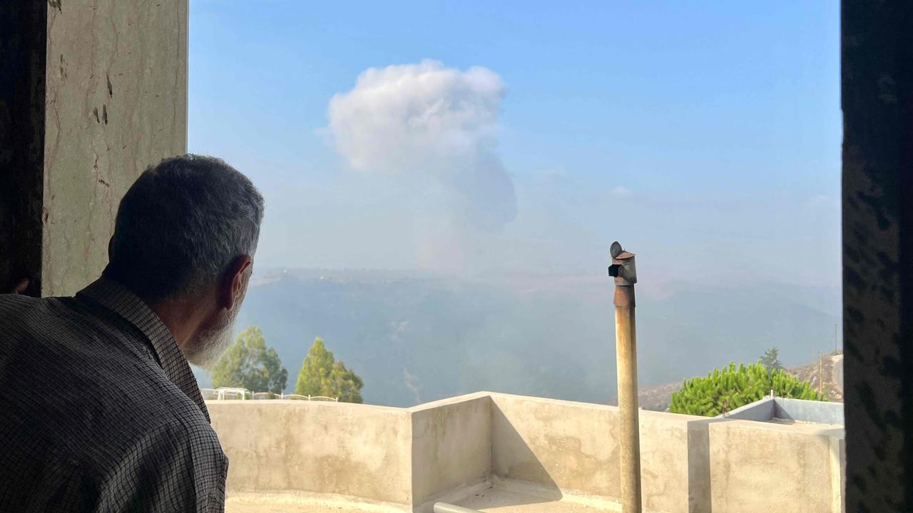 A man watches smoke billow after an Israeli air strike in the southern Lebanese village of Qsair on August 25. Picture: AFP