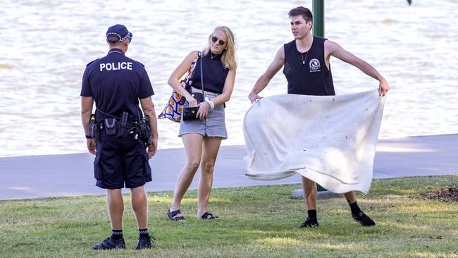 Queensland Police speak to a couple at New Farm Park. Picture: Richard Walker