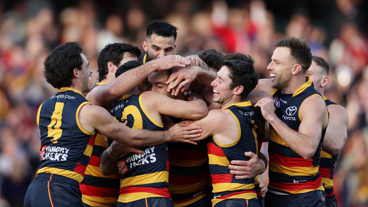 Taylor Walker is mobbed by teammates during his rampage against the Eagles. Picture: Sarah Reed/AFL Photos via Getty Images.