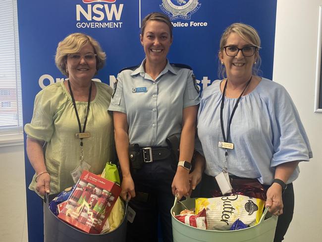 Staying Home Leaving Violence case manager Kate Hilder, senior constable Melissa Bennett and case manager Tracey Connell holding Christmas hampers.