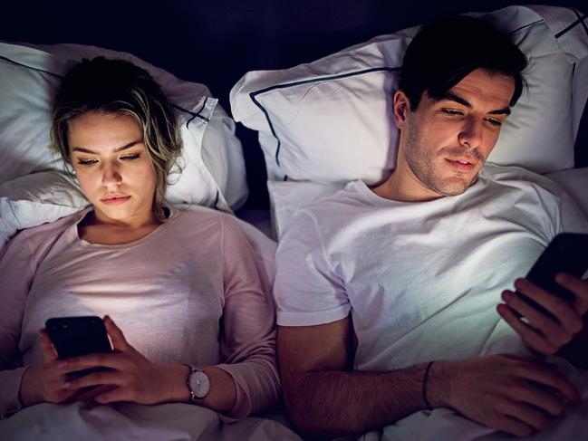 Mobile phone addiction - couple is texting and browsing in the bed