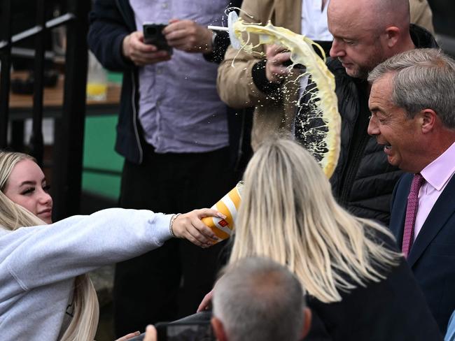 A person throws the contents of a drinks cup in the face of newly appointed leader of Britain's right-wing populist party, Reform UK, and the party's parliamentary candidate for Clacton, Nigel Farage, during his general election campaign launch in Clacton-on-Sea, eastern England, on June 4, 2024. Nigel Farage on Monday said he would stand as a candidate for the anti-immigration Reform UK party in Britain's general election next month, after initially ruling out running. "I have changed my mind... I am going to stand," Farage, 60, told a news conference. He will seek election on July 4 in the fiercely pro-Brexit seat of Clacton, southeast England. (Photo by Ben Stansall / AFP)