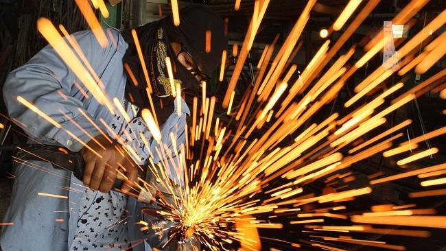 A Thai worker welds a joint of a steel gate in Bangkok, Thailand, Thursday, July 5, 2012 in Bangkok, Thailand. (AP Photo/Sak...