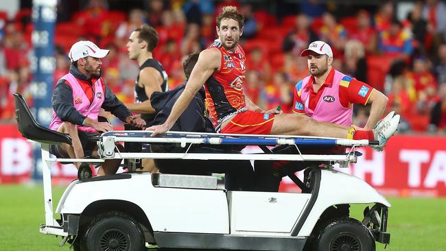 Michael Barlow of the Suns is taken from the field after hurting his ankle.