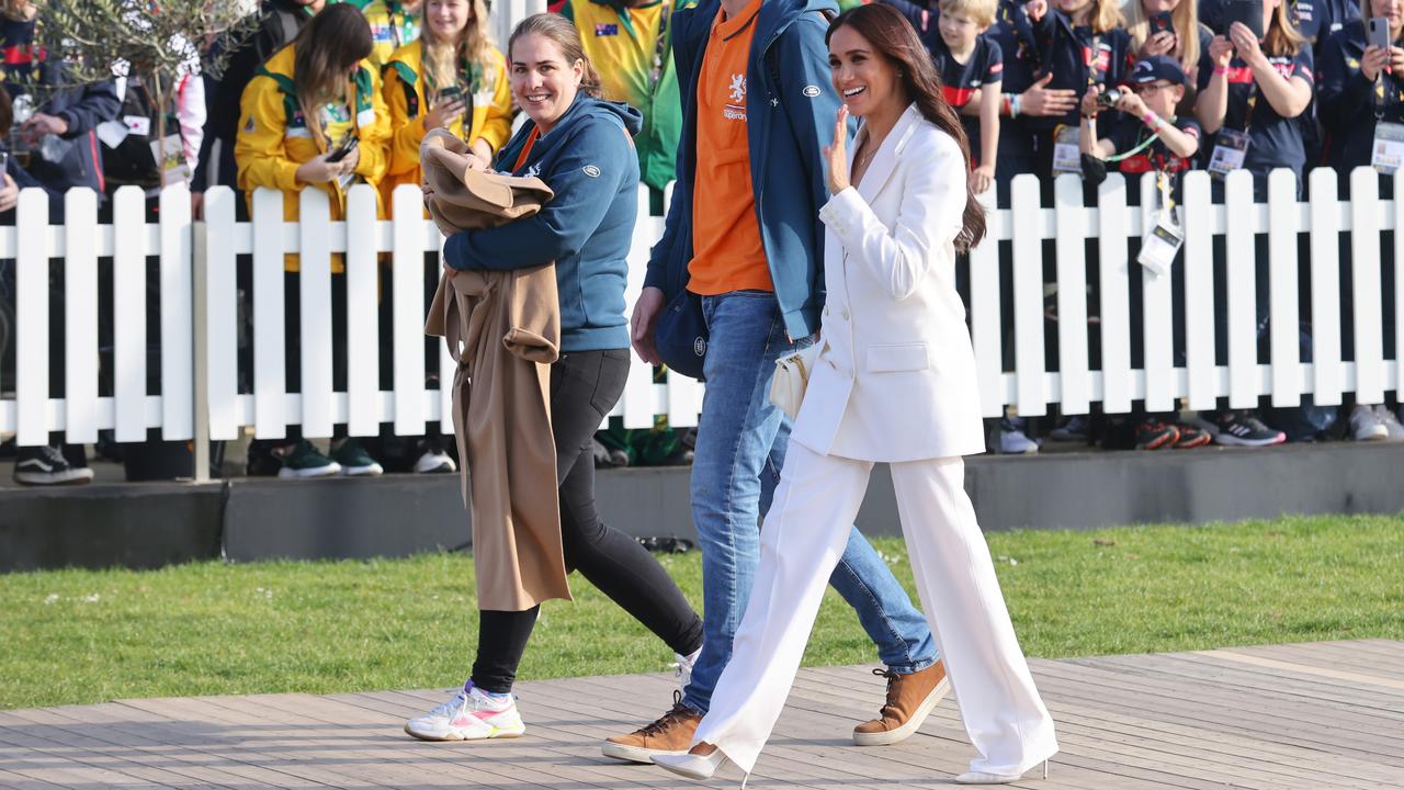 Meghan arriving to a reception with one of her party carrying her camel coat. Picture: Joern Pollex/Getty Images for Invictus Games The Hague 2020