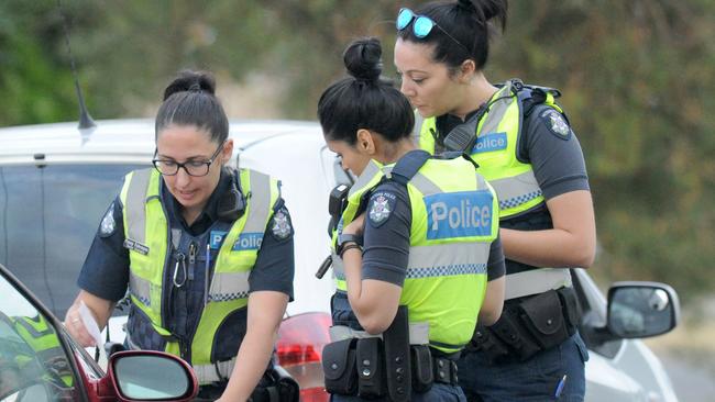 Police officers swarm the crime scenes. Picture: Andrew Henshaw