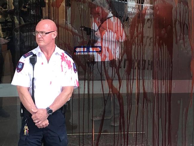 University of Queensland security guard covered in fake blood thrown by protesters during a visit to the Prime Minister Scott Morrison Picture Refugee Solidarity Meanjin Facebook page