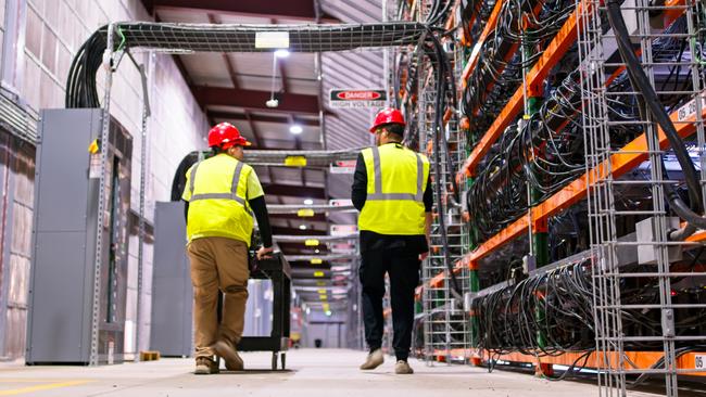 Two technicians at a data centre for cryptocurrency mining, cloud services and AI computing in the YS state of North Dakota.