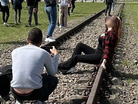 Woman spotted posing in front of Auschwitz memorial. Picture: Twitter