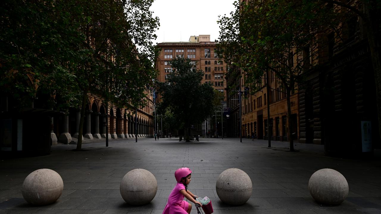 A girl rides her bike through an empty Martin Place in Sydney, Monday, April 13, 2020. (AAP Image/Joel Carrett)