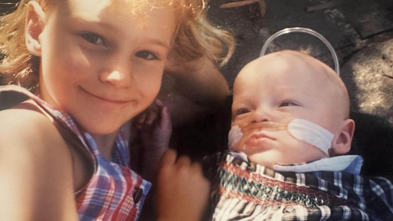 Many family photos were lost in the fire but this one remains precious to mum Angela, it shows Elizabeth with her little brother James who was attached to oxygen for the first year at home. Picture: Supplied