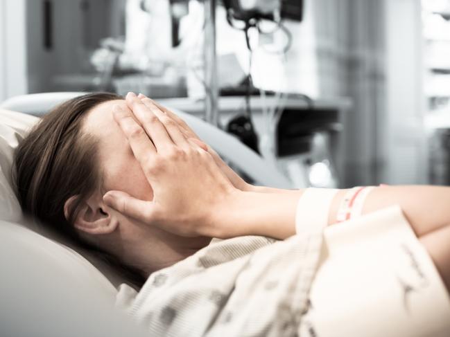 Young woman patient lying at hospital bed feeling sad and depressed worried. Disease feeling sick in health care and clinical attention concept.Picture: iStock