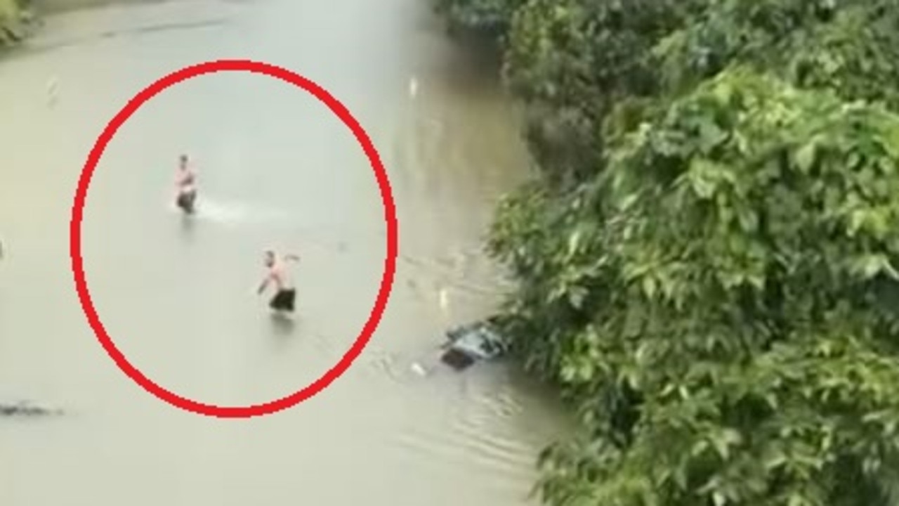 VIDEO: Pair risk it all as floodwaters rise in Far North Queensland