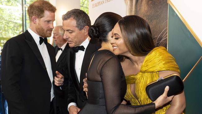 Prince Harry, Duke of Sussex chats with Disney CEO Robert Iger as Meghan, Duchess of Sussex embraces Beyonce at the London premiere of The Lion King. Picture: Niklas Hallen/Pool/AFP