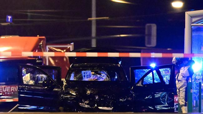 Forensics police inspect the car that sped through the narrow streets of the old town. Picture: AFP