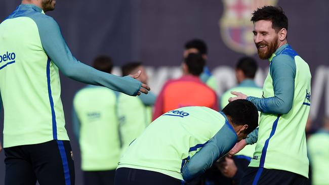 Lionel Messi (R), jokes with Barcelona's Uruguayan forward Luis Suarez (C).
