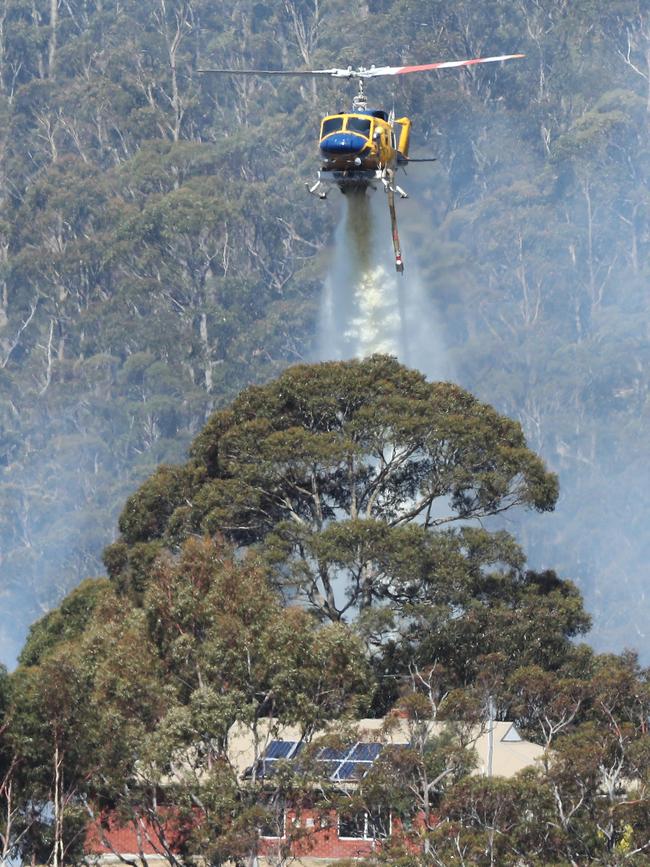 Helicopter dumps water on a home during a bushfire on Collinsvale Road at Glenlusk. Picture: NIKKI DAVIS-JONES