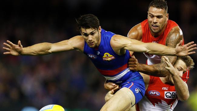 Easton Wood is tackled by Lance Franklin and Luke Parker.