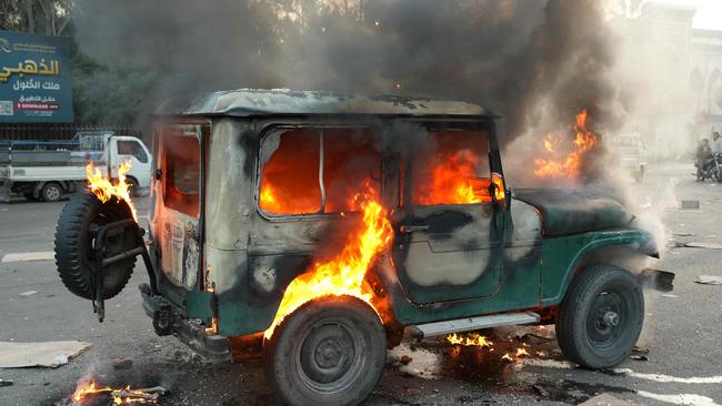 A vehicle burns after anti government forces ransacked government security facilities, in Damascus, as Assad’s regime fell. Picture: AFP