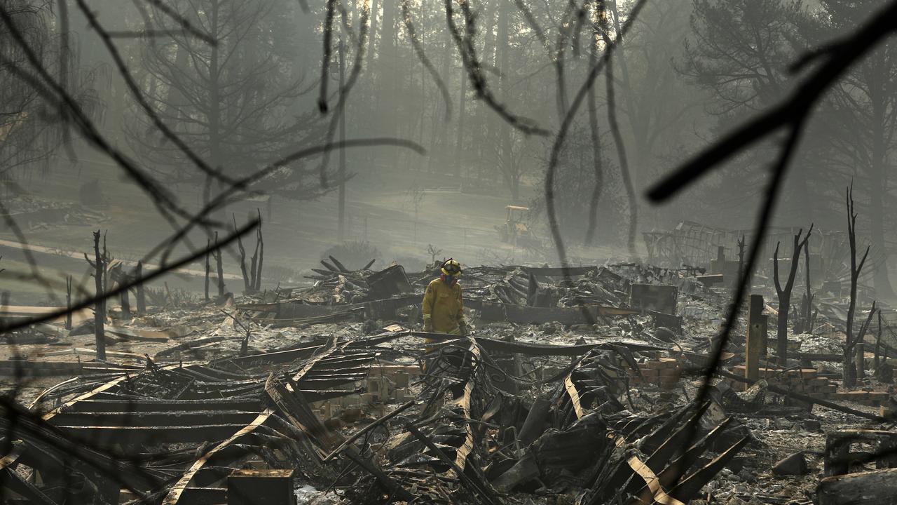 A firefighter searches for human remains in a trailer park destroyed in the Camp Fire in Paradise, California. Picture: AP/John Locher