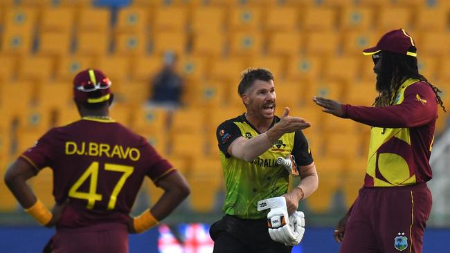 David Warner speaks with West Indies' Chris Gayle, right, as West Indies' Dwayne Bravo watches at the end of the Twenty20 World Cup cricket match between Australia and West Indies. Picture: Indranil Mukherjee / AFP