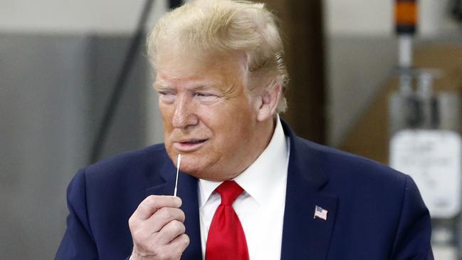 Donald Trump holds a medical swab he tours Puritan Medical Products in Guilford, Maine on Friday. Picture: AP