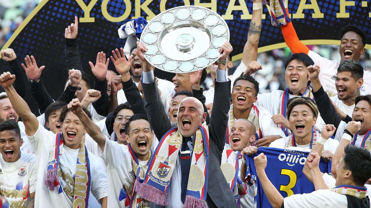 Yokohama F Marinos manager Kevin Muscat (C) holds up the trophy as he celebrates with teammates after taking Japan's professional J-League football title following their 3-1 victory over Vissel Kobe to put them at the top of the standings, in Kobe on November 5, 2022. (Photo by JIJI Press / AFP) / Japan OUT