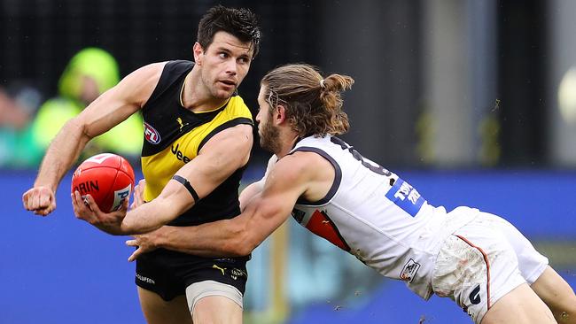 Trent Cotchin clears by hand as he is tackled by Callan Ward. Picture: Michael Klein