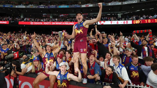 Lions players celebrates with fans after Brisbane win the AFL Grand Final. Picture: Lachie Millard