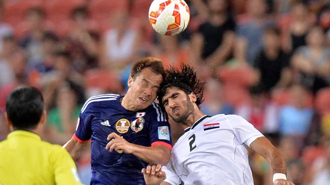 Shinji Okazaki of Japan and Ahmed Ibrahim of Iraq compete for the ball.