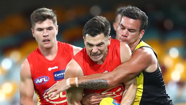 BRISBANE, AUSTRALIA - AUGUST 17: Ben Ainsworth of the Suns is tackled during the round 12 AFL match between the Richmond Tigers and the Gold Coast Suns at The Gabba on August 17, 2020 in Brisbane, Australia. (Photo by Jono Searle/AFL Photos/via Getty Images)