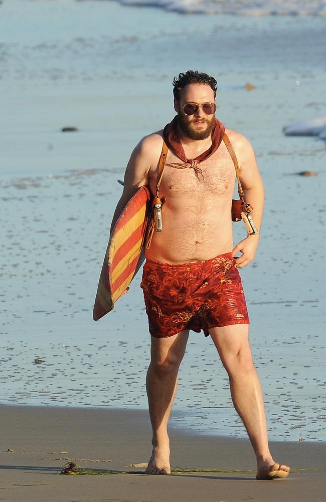 Actor Seth Rogen is lock and loaded on the beach and ready to surf for the movie "Zeroville" in 2014. Picture: Wenn.com/Alamy