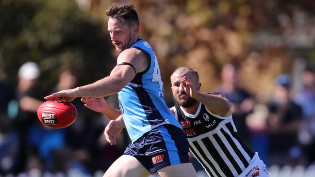 Sturt’s Aidan Riley gets his kick away under pressure from Port’s Josh Simpson.