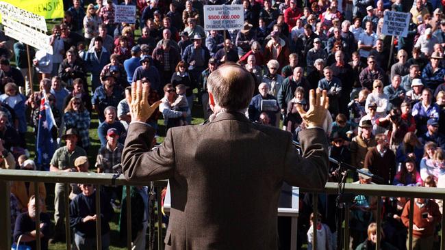 Prime minister John Howard wears a bullet-proof vest in front of a pro-gun crowd in Sale, Victoria. Howard pushes through gun control after the Port Arthur massacre. Picture: Ray Strange