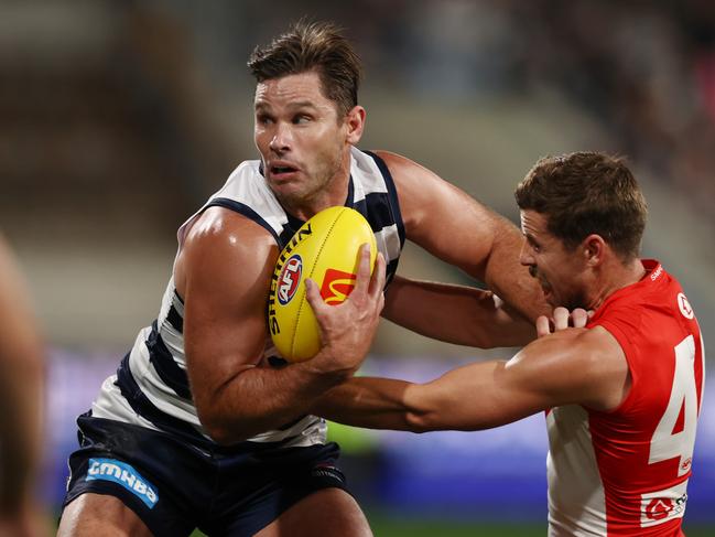 MELBOURNE. 19/04/2023. AFL. Round 6. Geelong vs Sydney Swans at GMHBA Stadium. Tom Hawkins of the Cats fends off Sydneys Jake Lloyd before goaling during the 2nd qtr. . Pic: Michael Klein