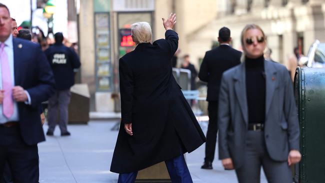 Donald Trump waves as he leaves 40 Wall Street after holding a news conference following his court hearing to determine the date of his trial for allegedly covering up hush money payments. Picture: AFP