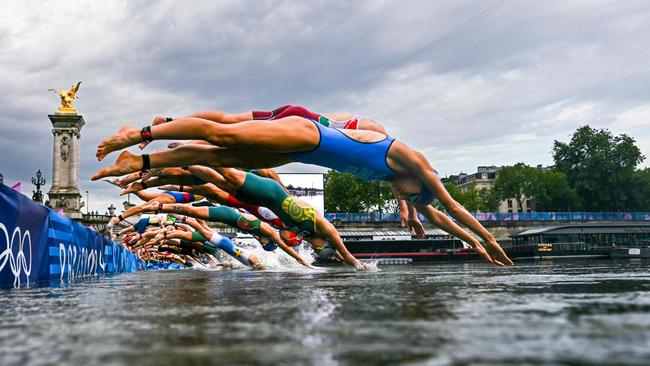 (FILES) Athletes compete in the swimming race in the Seine during the women's individual triathlon at the Paris 2024 Olympic Games in central Paris on July 31, 2024. Paris Olympics organisers have cancelled training for triathletes in the River Seine again because of poor water quality, leading to more uncertainty over whether the mixed relay will go ahead as planned on August 5, 2024. (Photo by MARTIN BUREAU / POOL / AFP)