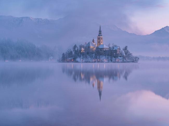 Mystic Island ... I was waiting eagerly for the first cold winter morning after the snowy day. Finally the conditions were just as I wanted them to be. Still lake, beautiful pink/purple morning tones, snow on the trees and some fog for mystic atmosphere. Picture: Aleš Krivec, Slovenia, 2nd Place, National Awards, 2017 Sony World Photography Awards
