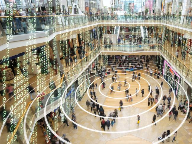 Radio waves spreading out from a mobile phone in a shopping mall with matrix style data layered on top.