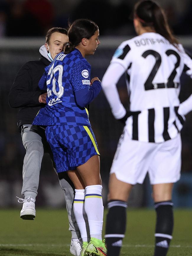 Sam Kerr takes out a pitch invader.