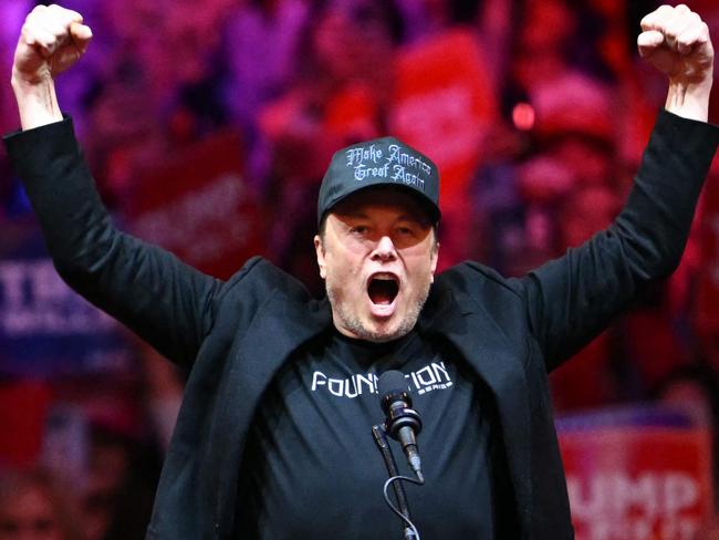 (FILES) Tesla and SpaceX CEO Elon Musk gestures as he steps on stage during a rally for former US President and Republican presidential candidate Donald Trump at Madison Square Garden in New York, October 27, 2024. Donald Trump will be the one taking the presidential oath next week, but in some respects, billionaire Elon Musk might as well place his hand on the Bible too.  In an unprecedented relationship for modern US history, Trump will be heading into the White House shadowed by an advisor who is not only the world's richest person but matches the incoming president in terms of wild ambition, hard-right politics, and media influence. (Photo by ANGELA WEISS / AFP)