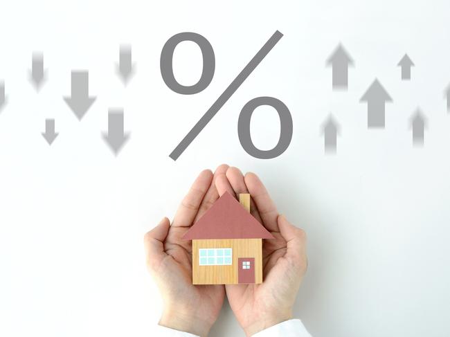 House object covered by human's hands and percentage sign with upward and downward arrows. home loan interest rate mortgage generic