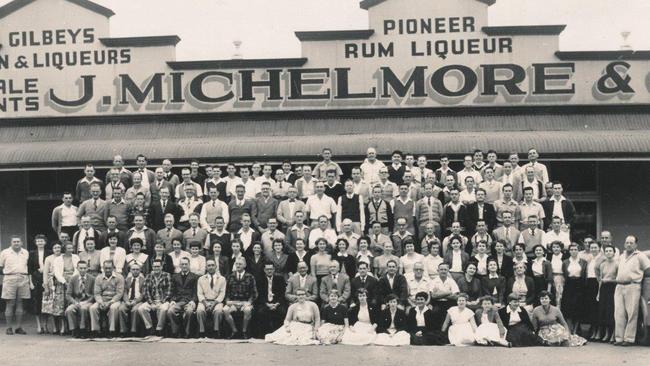 Staff photo of J. Michelmore &amp; Co staff taken July 17, 1957 in front of the company's warehouse on River St, Mackay.