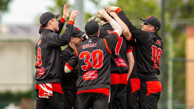 Cam McClure is mobbed by teammates after claiming his first wicket. Picture: Arj Giese