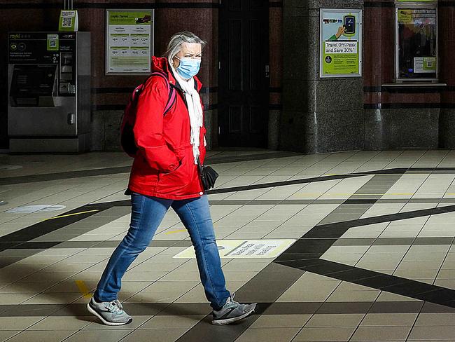 MELBOURNE, AUSTRALIA - NewsWire Photos 26 JULY 2021 : A woman passes through Flinders Street station as Melbourne and the state of Victoria continues its lockdown.  Some restrictions may be lifting as cases drop of the Delta Covid-19 variant. Picture : NCA NewsWire / Ian Currie