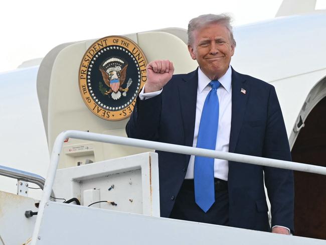 US President Donald Trump raises a fist as he steps off of Air Force One upon arrival at Tuscaloosa National Airport in Tuscaloosa, Alabama, on May 1, 2025. Trump is headed to the University of Alabama to deliver remarks at a commencement. (Photo by SAUL LOEB / AFP)